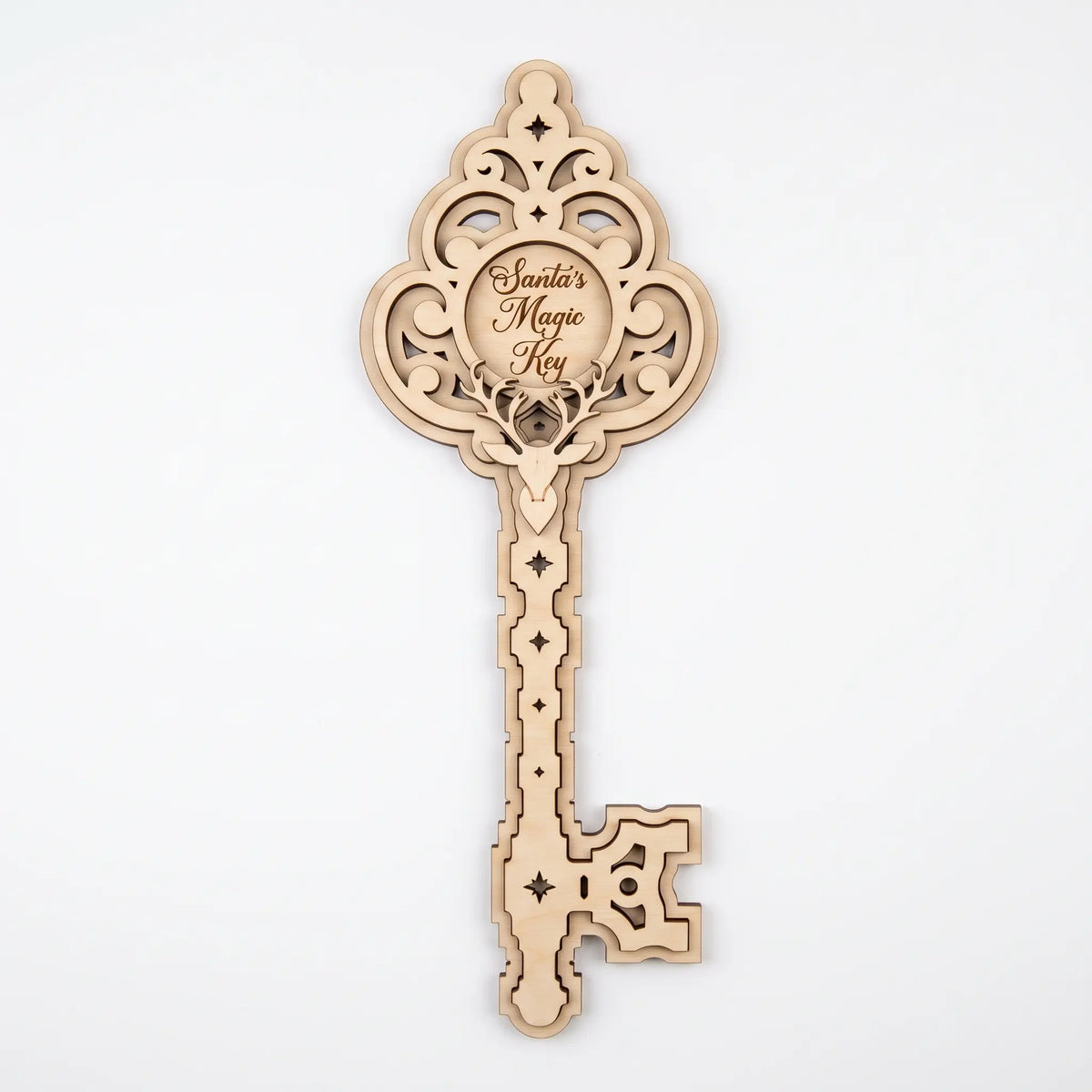 Front view of 3D layered laser cut plywood Santa magic key ornament with deer head and carved stars on white background.