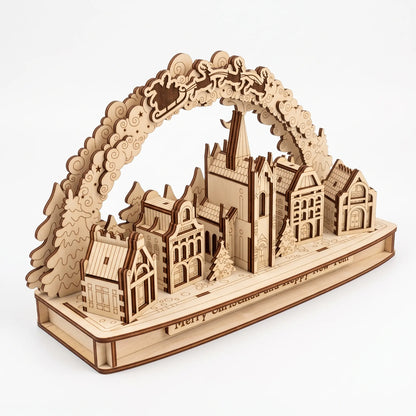 High-angle view of 3D laser cut plywood Christmas village arch with church, miniature houses, and Santa on white background.