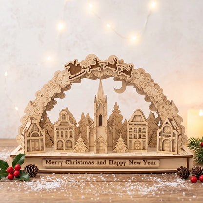 Laser cut plywood Christmas village arch diorama on snow-dusted rustic table decorated with holly berries and fairy lights.