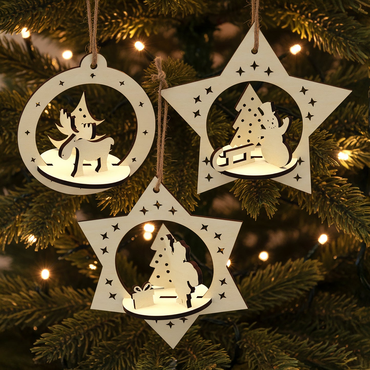Laser cut wooden Set of 3 Christmas toys featuring layered 3D scenes of a reindeer, snowman with tree and Santa placing gifts inside star and circle frames, displayed against a warm lighted Christmas tree background.