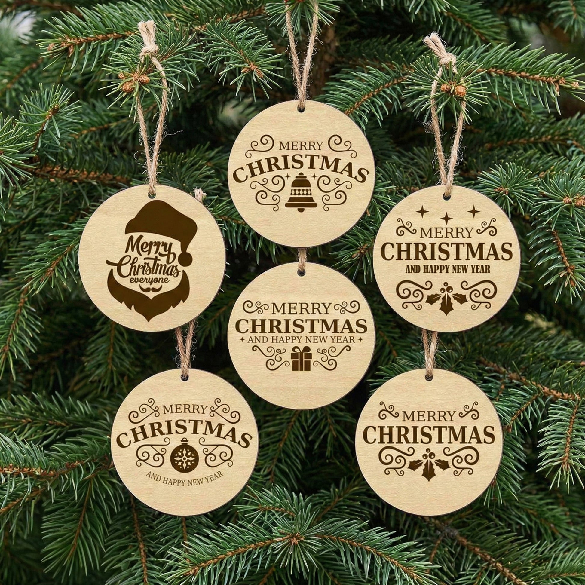 Collection of 6 delicate laser cut wooden Christmas tree toys in circular shapes with elegant holiday greetings and decorative motifs, displayed hanging from branches on a lush green Christmas tree background.