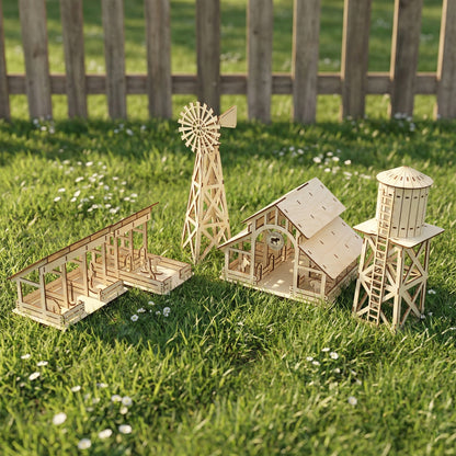 A high-angle view of a farm set made from laser cut plywood, featuring a barn, windmill, water tower, and animal stalls. The natural wood models sit on green grass with small white flowers, showing detailed interlocking wood joints.