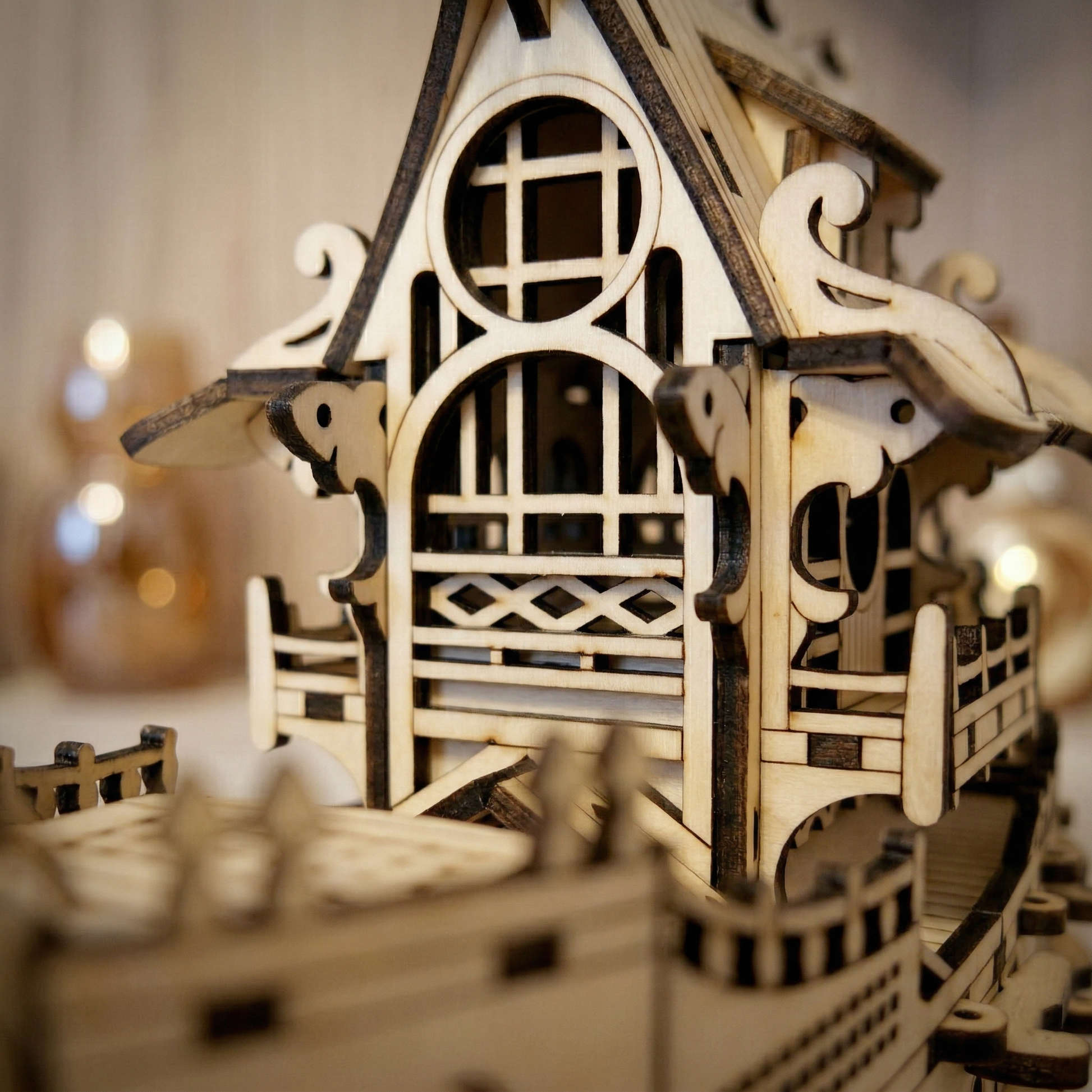 Wooden laser cut model of a ship with intricate details on a blurred background