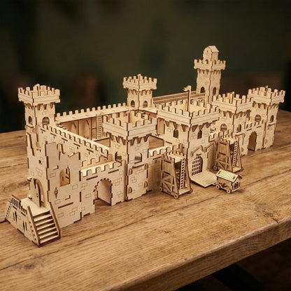 An expansive medieval castle toy set with walls and towers, accompanied by siege weapons, all made from laser cut plywood. The large-scale model is intricately detailed with etched stone patterns and modular sections.