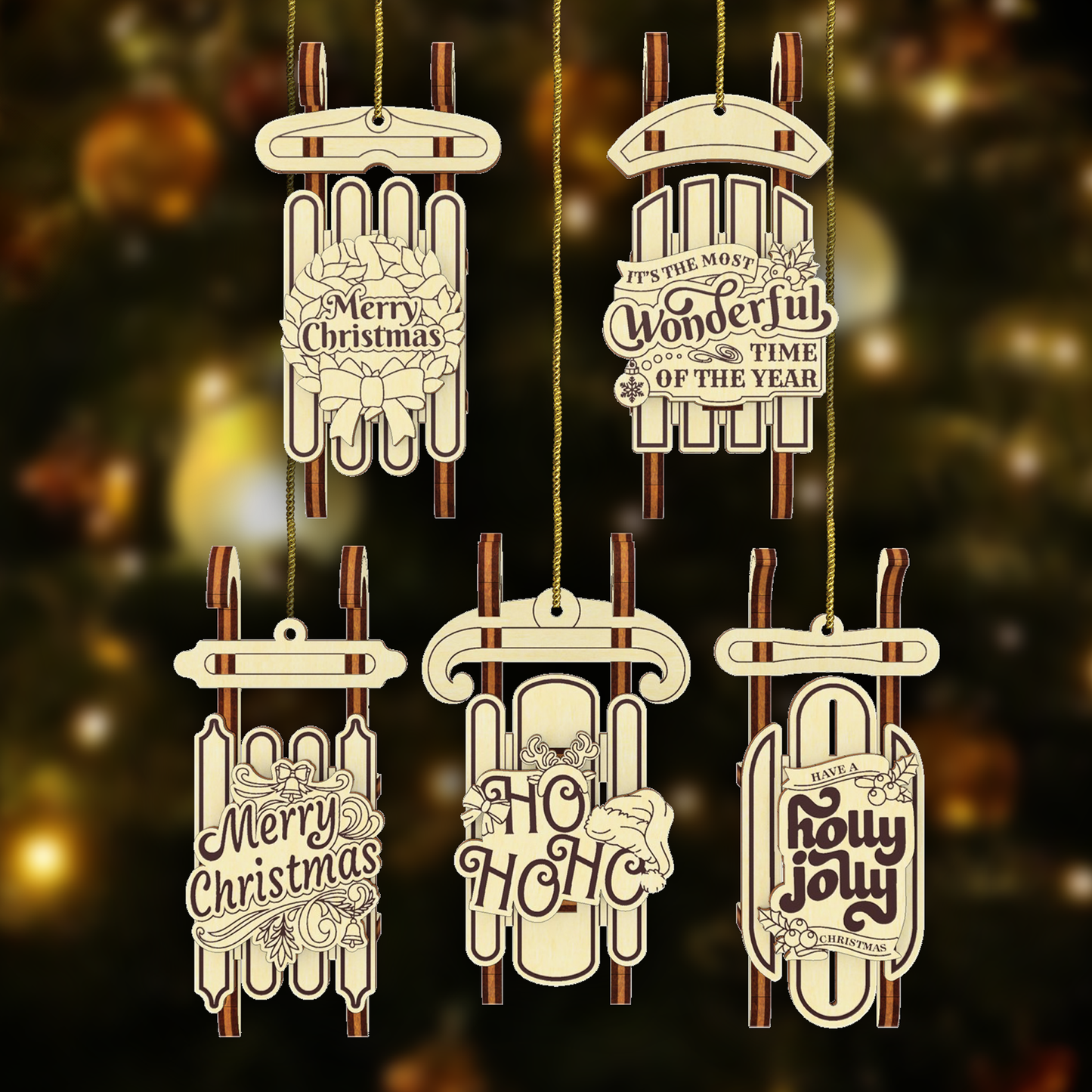 Five laser cut wooden Christmas sled ornaments with engraved festive phrases such as “Merry Christmas” and “Ho Ho Ho,” hanging on golden strings against a blurred holiday lights background.