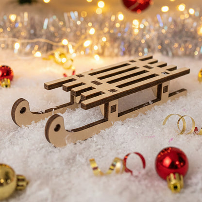 
Laser cut wooden Sleigh for christmas with detailed curved runners and slatted seat, displayed against a snowy festive bokeh background with Christmas tree lights.