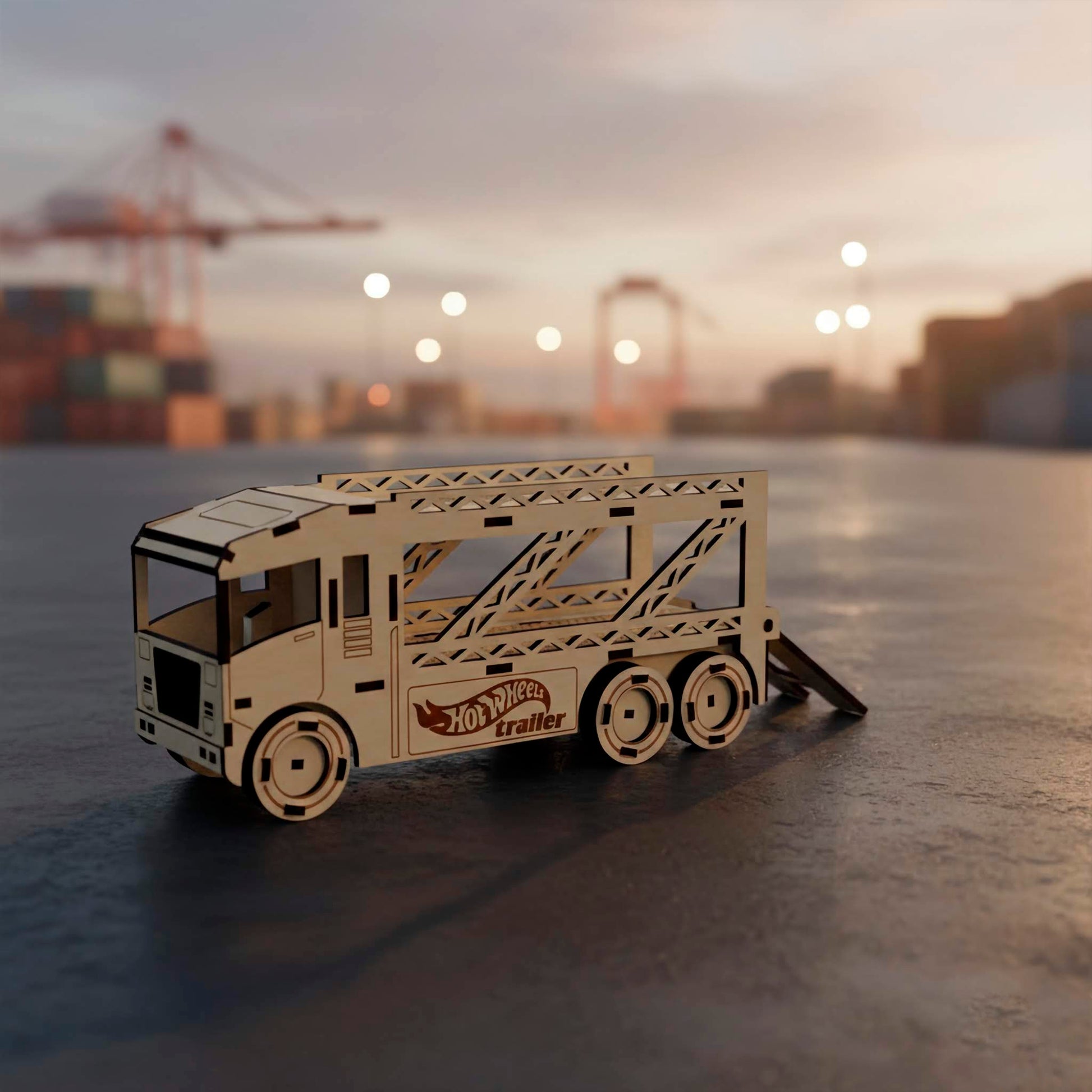 Full side view of a laser cut wooden plywood car hauler with a lowered rear ramp for loading. This detailed plywood toy features lattice-style trailer sides and an engraved logo, photographed at a cargo port with cranes in the distance.