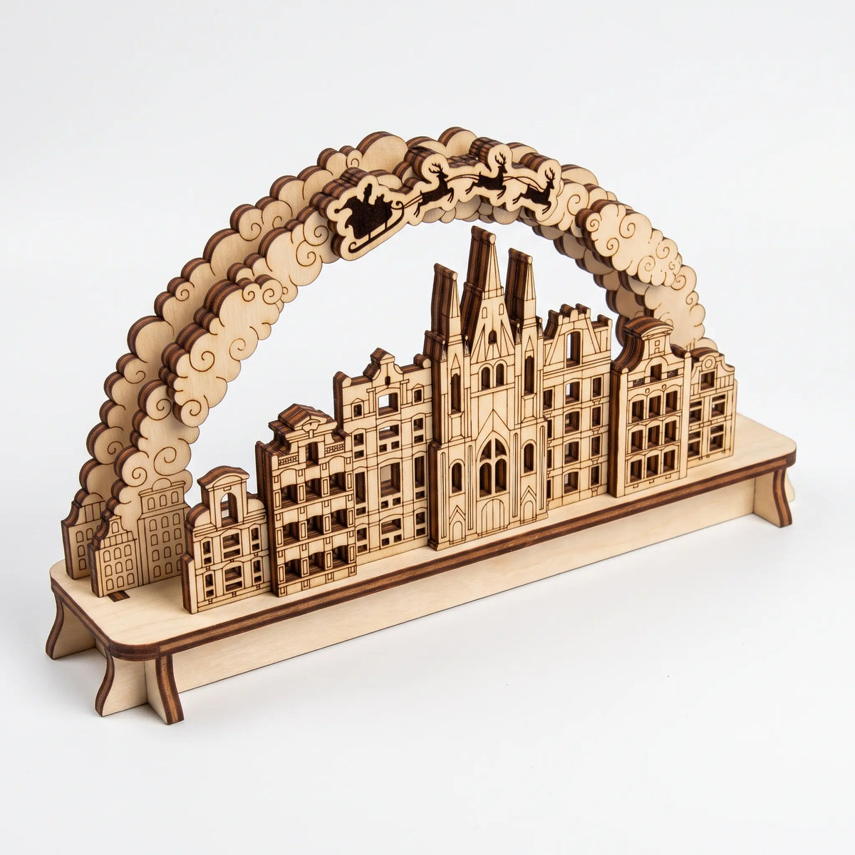 Isometric view of unpainted 3D laser cut plywood Christmas town arch diorama with cathedral and houses on white background.