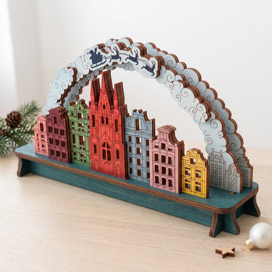Colorful painted laser cut plywood Christmas city arch with cathedral, townhouses, and Santa sleigh on curved cloud arch.
