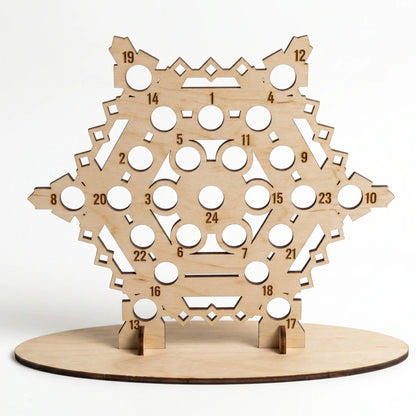 Front view of empty laser cut plywood snowflake advent calendar stand with numbered holes on white backdrop