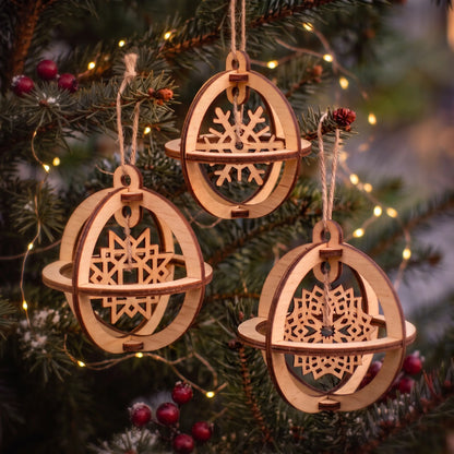 Set of three 3D laser cut plywood sphere ornaments with suspended snowflakes hanging on lit Christmas tree