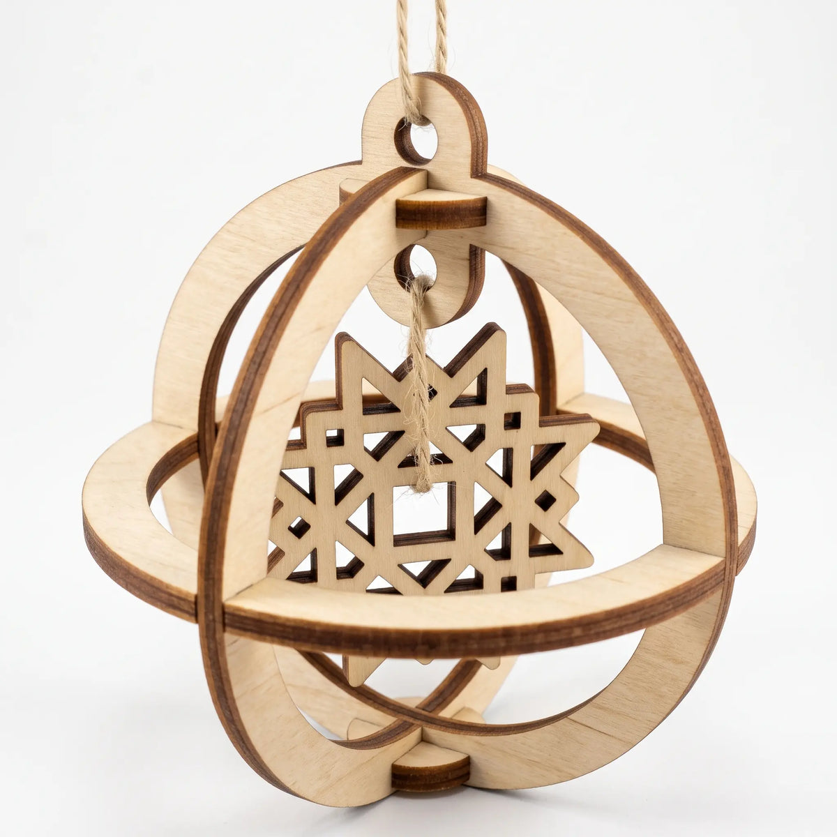 3D laser cut plywood spherical bauble featuring an internal suspended geometric star ornament on white backdrop