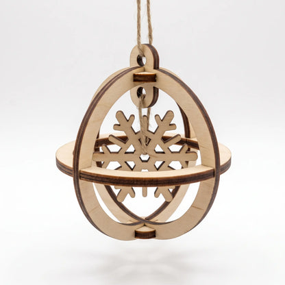 Single 3D laser cut plywood globe ornament displaying an inner suspended snowflake cutout isolated on white.