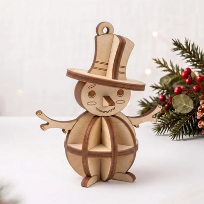 3D laser cut plywood snowman ornament with top hat standing near pine branch, red berries, and holiday lights on white table.