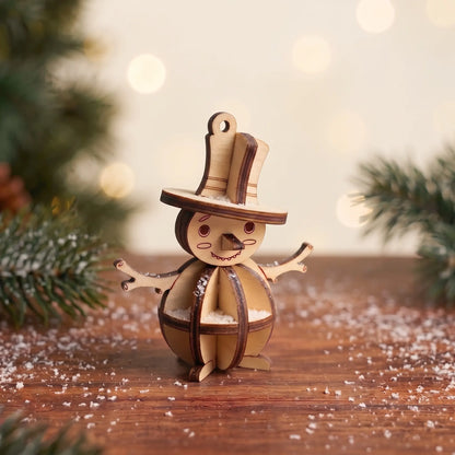 Laser cut plywood snowman figurine with top hat on snowy rustic table in front of holiday tree with glowing bokeh lights.