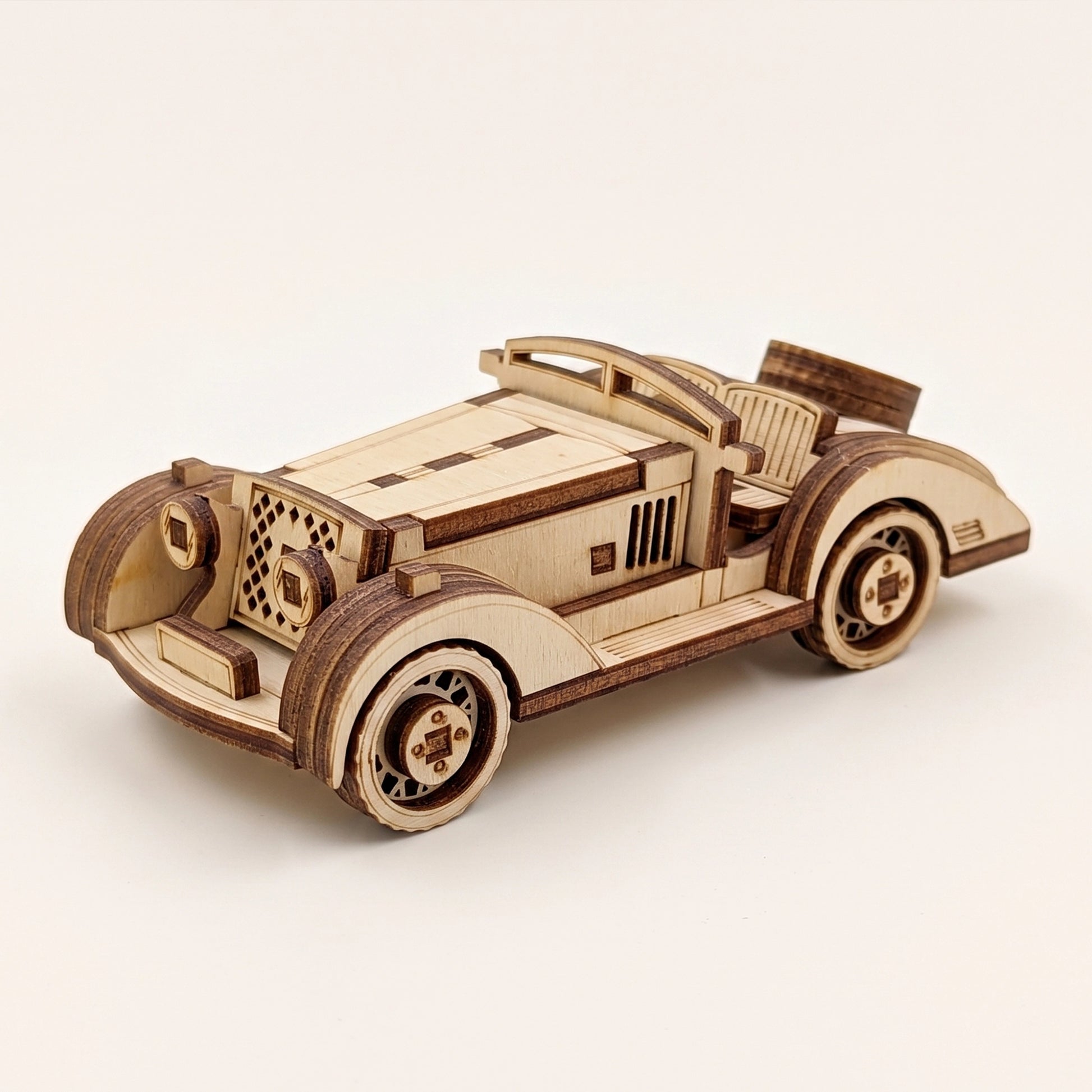 Three-quarter view of a vintage style sport car, showcasing precision details in this laser cut plywood model.