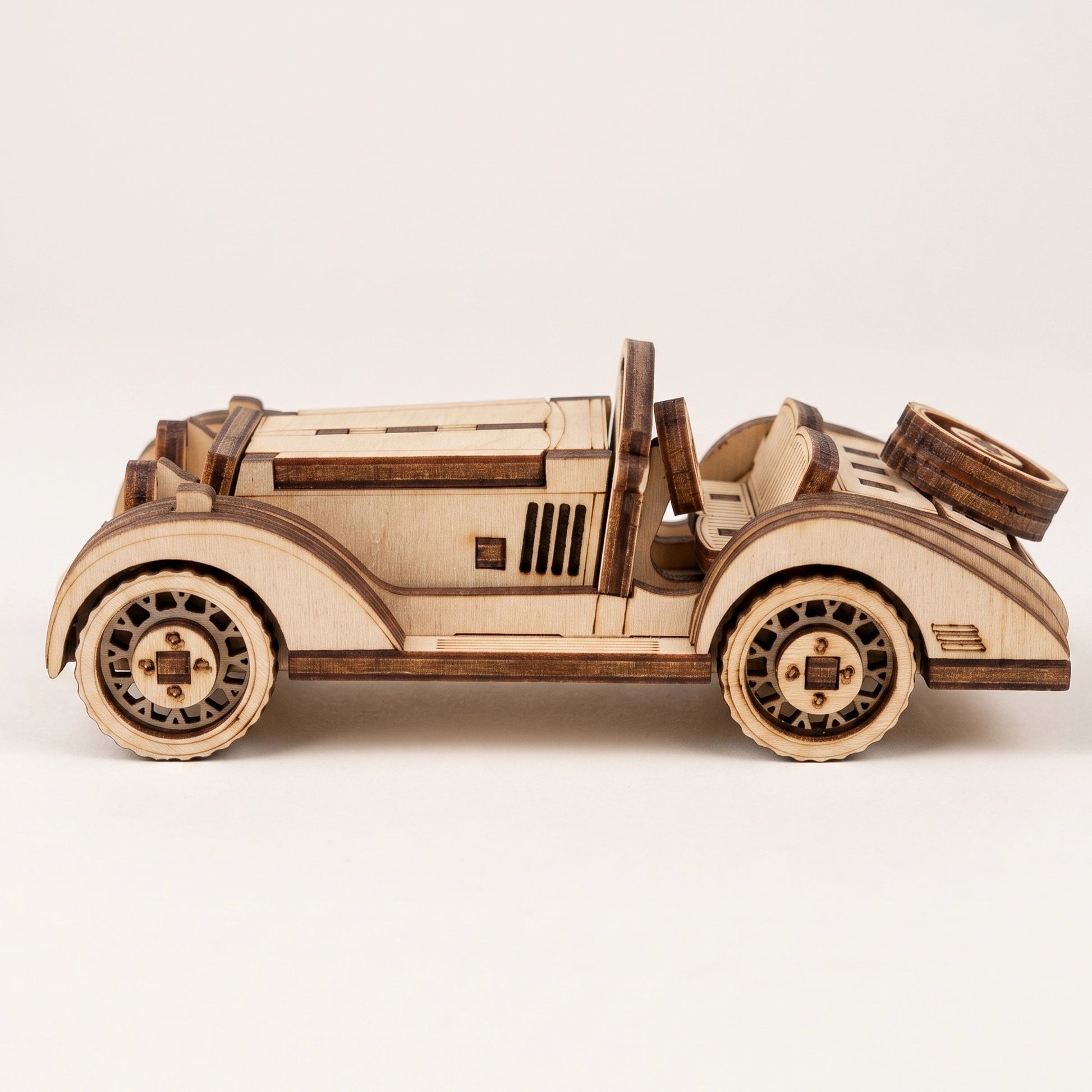 Side profile of a vintage sport car model, featuring detailed laser cut plywood construction and wood grain.
