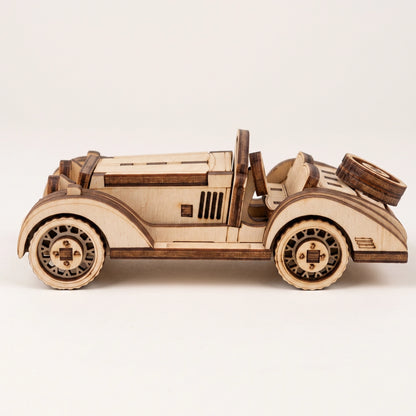 Side profile of a vintage sport car model, featuring detailed laser cut plywood construction and wood grain.