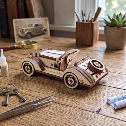 Assembled laser cut plywood sport car on a wooden workbench with crafting tools, glue, and blueprints nearby.
