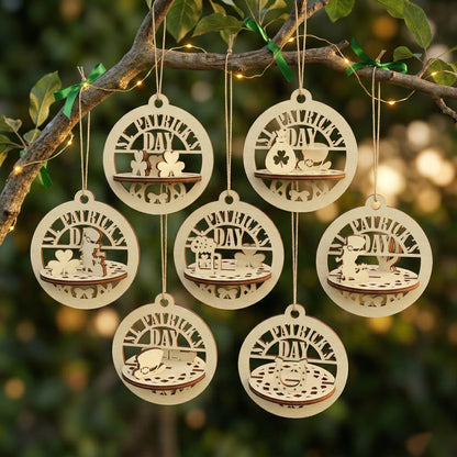 A set of seven 3D laser-cut plywood St. Patrick's Day ornaments hanging from a tree branch decorated with green ribbons and fairy lights. Each circular ornament features a unique miniature scene, including shamrocks, a pot of gold, a leprechaun hat, and a beer mug, with "ST. PATRICK'S DAY" engraved at the top.