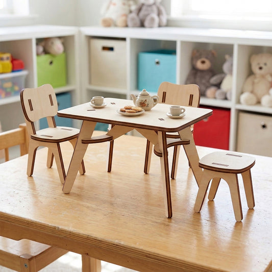 Miniature tea party set made of laser cut plywood. Features a small rectangular table with a tiny teapot and cookies, two chairs, and a stool. Light natural wood with dark burnt edges, shown on a wooden surface in a playroom.