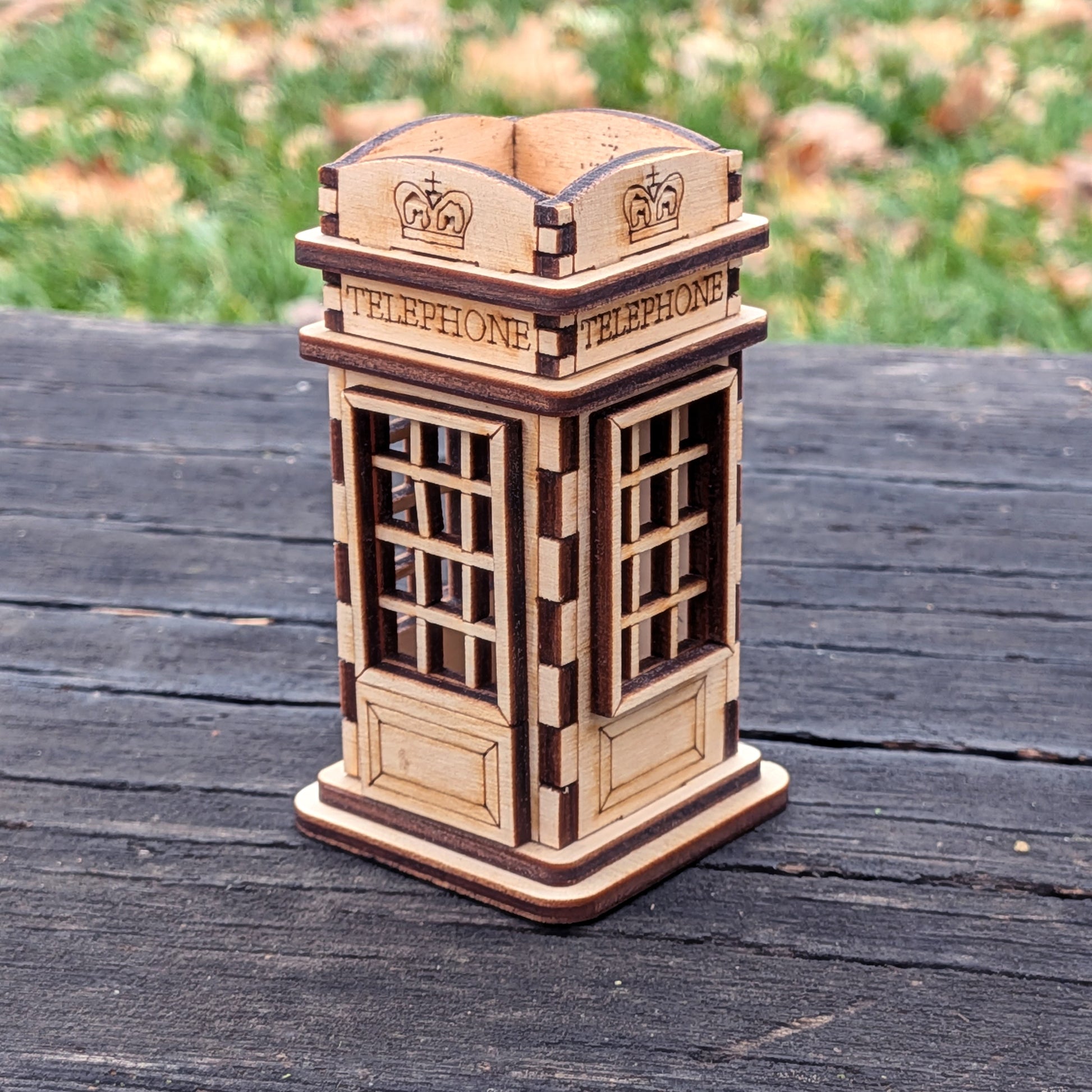 Laser cut wooden telephone booth storage box with open top design, crafted from layered plywood and featuring engraved “TELEPHONE” text and crown symbols.