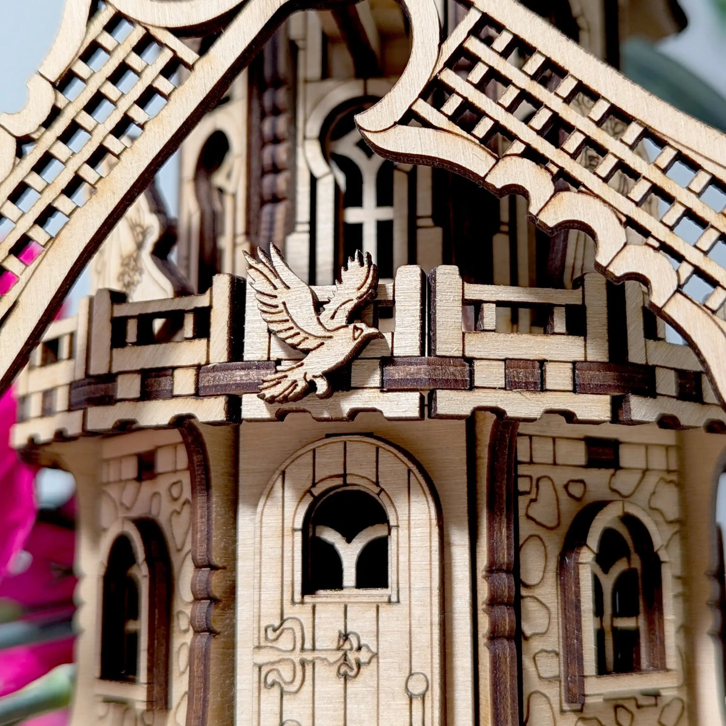 Extreme close-up view of a small engraved flying bird emblem attached to a decorative laser cut plywood windmill deck.