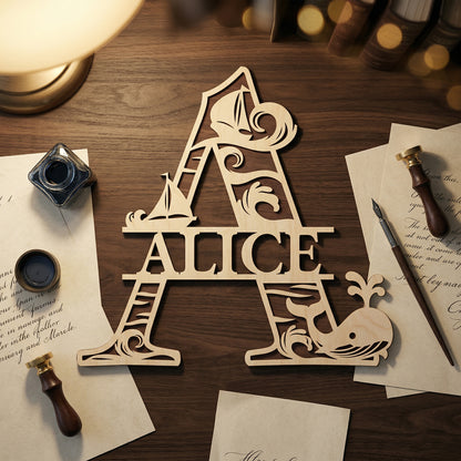 Handcrafted wooden name sign for Alice in a large letter A shape. Features intricate laser-cut ocean details, including waves and a whale icon. Posed on a dark wood desk surrounded by vintage stationery, inkwells, and wax seals for a classic nursery decor aesthetic.