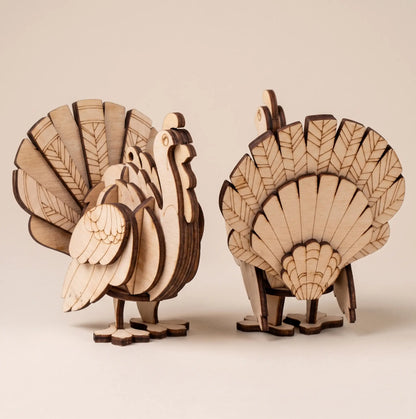 Two wooden turkey laser cut models on a beige background