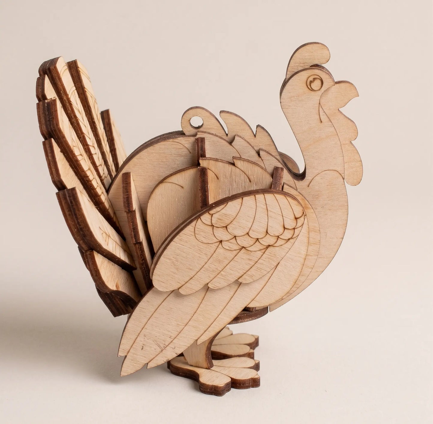 Wooden 3D puzzle of a laser cut turkey on a beige background