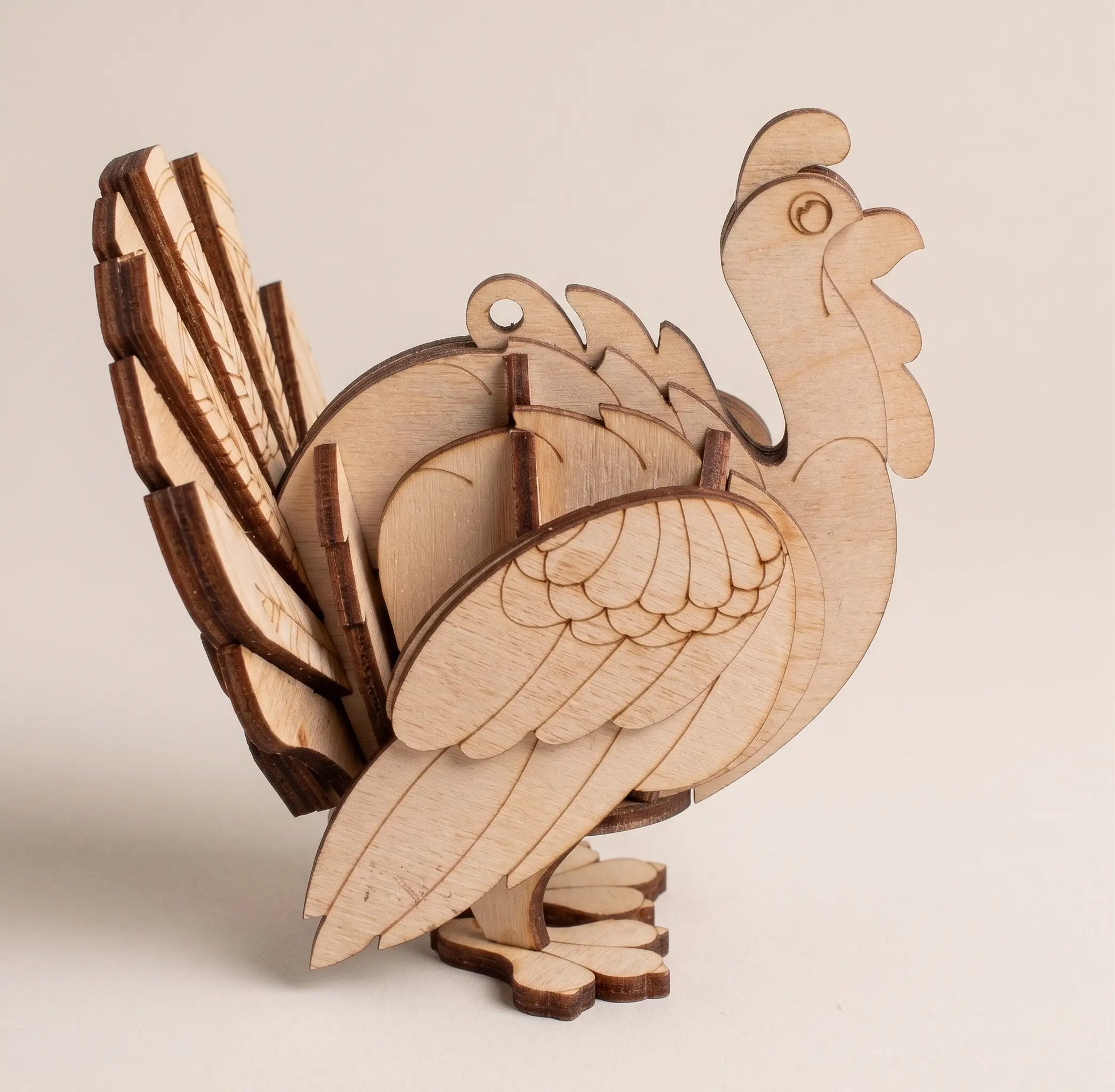 Wooden 3D puzzle of a laser cut turkey on a beige background