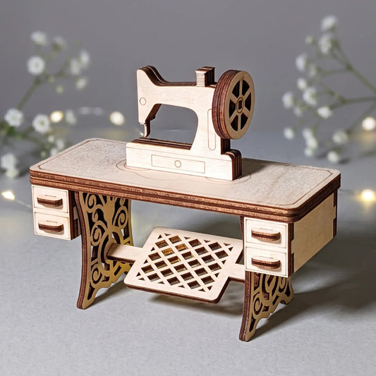 A wooden sewing machine laser cut model is displayed on a desk, with a background of white flowers and twinkling lights.