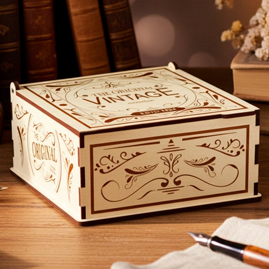 Laser cut plywood wooden keepsake box with a vintage engraved design on the lid and sides, displayed on a dark wooden desk next to stacked antique books, fountain pens, and a white teacup in warm lighting.