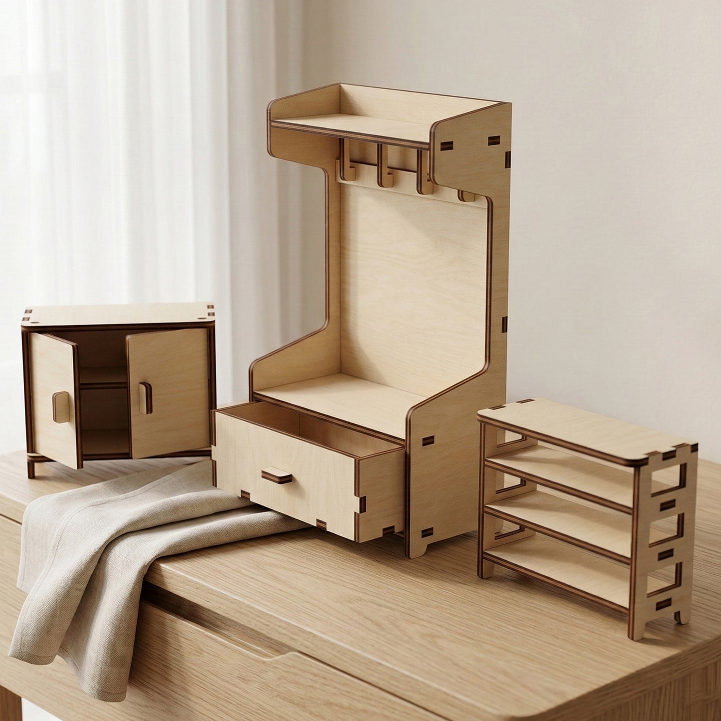 Detail shot of laser cut plywood doll furniture showing functional parts. A sideboard features opening doors and a hall tree includes a sliding drawer. The natural wood pieces show precise joints for sturdy DIY assembly.