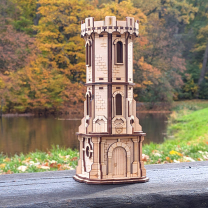 Wooden laser cut model of a castle tower on a wooden surface with a natural background.