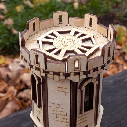 A sharp high-angle close-up view of the detailed engraved top battlement rooftop of a miniature tower in laser cut plywood