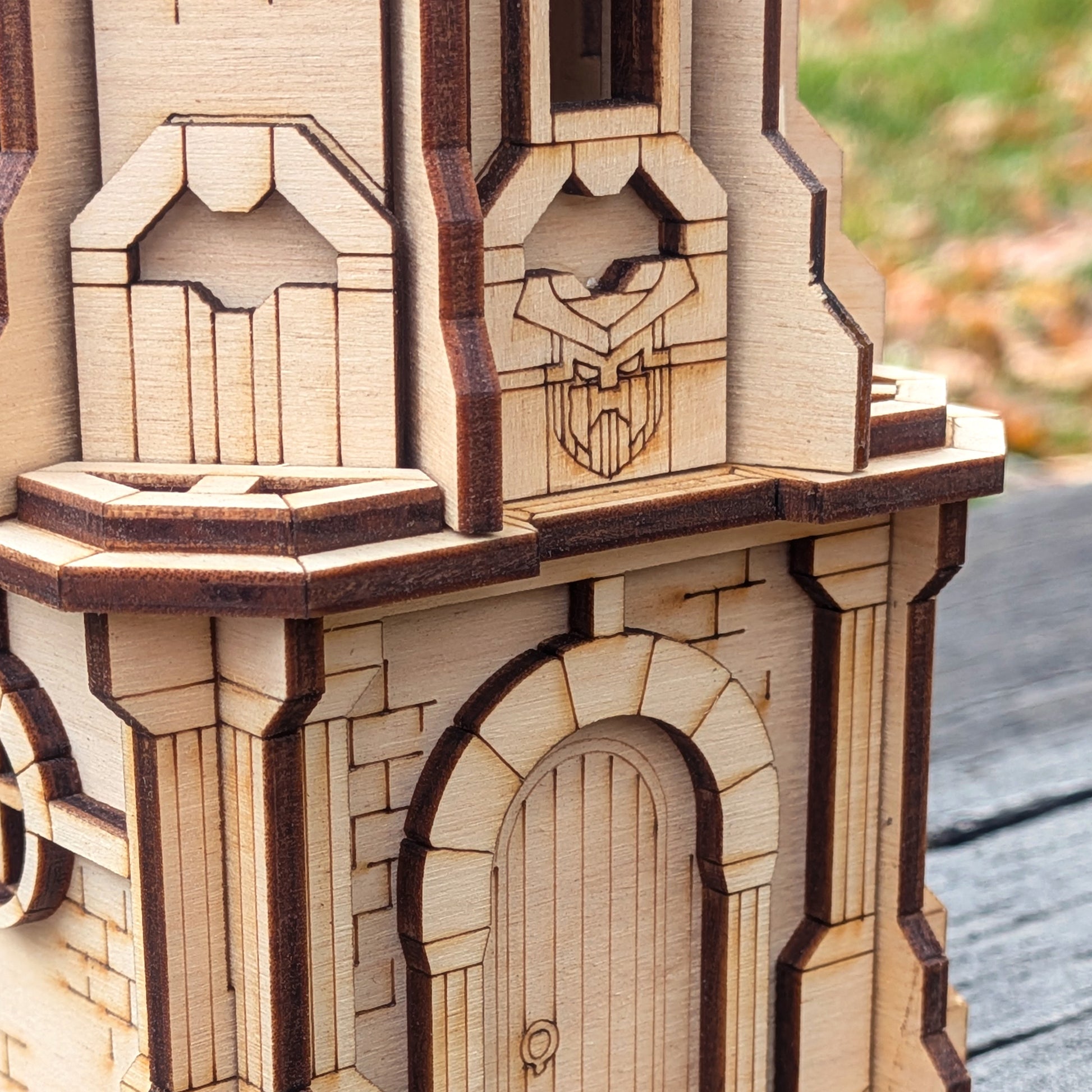 Close-up of a wooden laser cut model of a castle or similar structure with intricate details.
