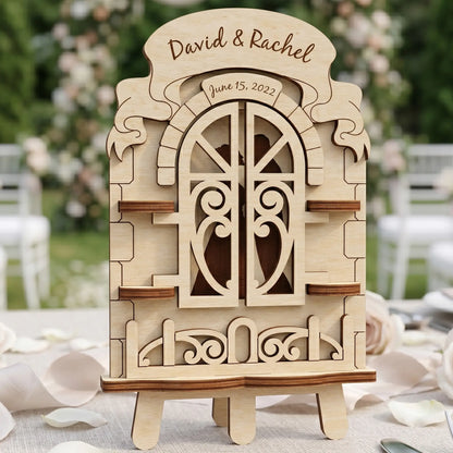 Laser cut plywood wedding window with closed heart-patterned shutters and personalized engravings on a white linen table.