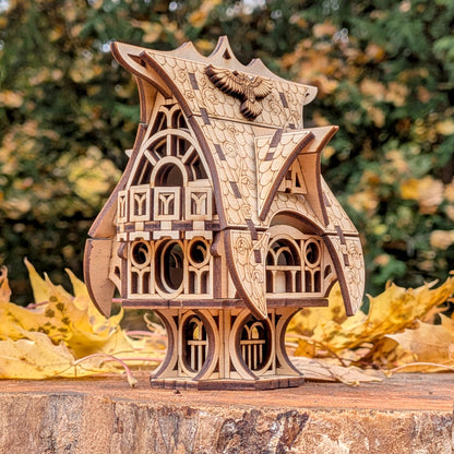 Side view of the laser cut fairy house, highlighting layered wood construction, detailed engraving, and whimsical curved roof, set against autumn foliage.