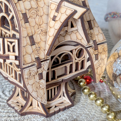 Close side view of the laser cut wooden fairy house, highlighting the arched windows, engraved patterns, and curved roof design.
