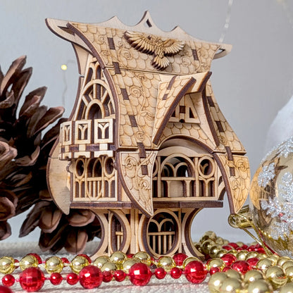 Atmospheric close-up shot of a whimsical miniature fairytale owl house in laser cut plywood, staged with red holiday beads.
