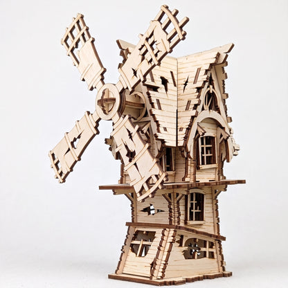 Three-quarter view of a laser-cut birch plywood Halloween windmill model with rustic windows and dark burnt edges.