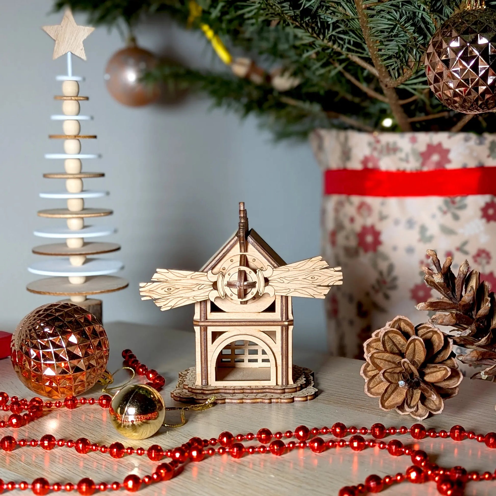 Festive Christmas holiday product staging photography of a tabletop miniature forest windmill made from laser cut plywood