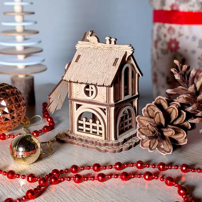 Side view of a miniature windmill with a textured thatched roof made of laser cut plywood, staged with red Christmas beads.