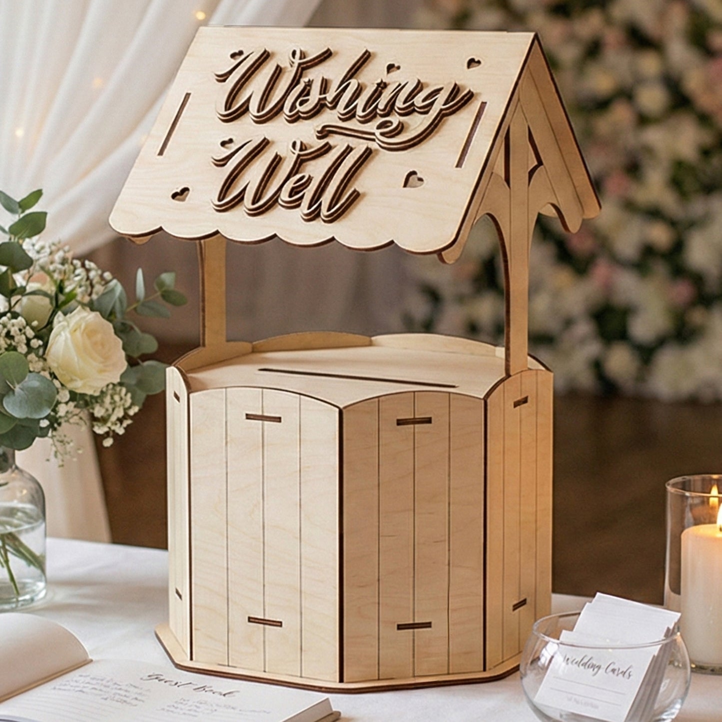 Laser cut wooden Wishing well card collector displayed on a white decorated table in a wedding reception background.