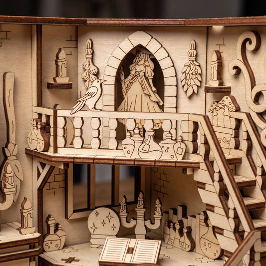 Wooden laser cut book nook model of a balcony scene with a witch, bird, and decorative elements.