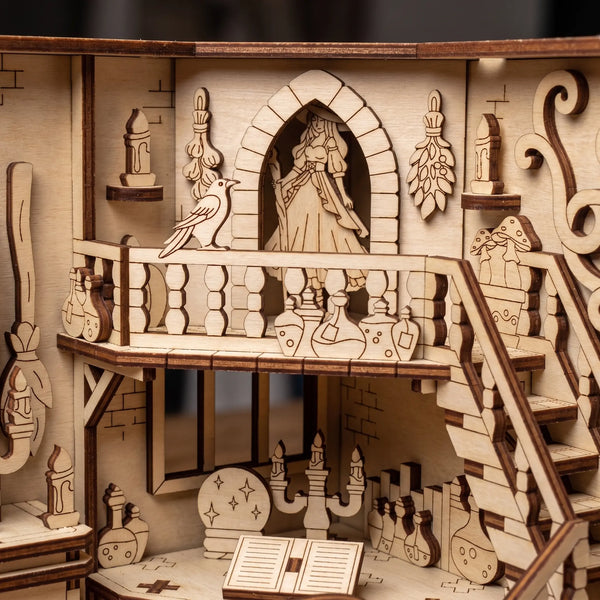 Wooden laser cut book nook model of a balcony scene with a witch, bird, and decorative elements.