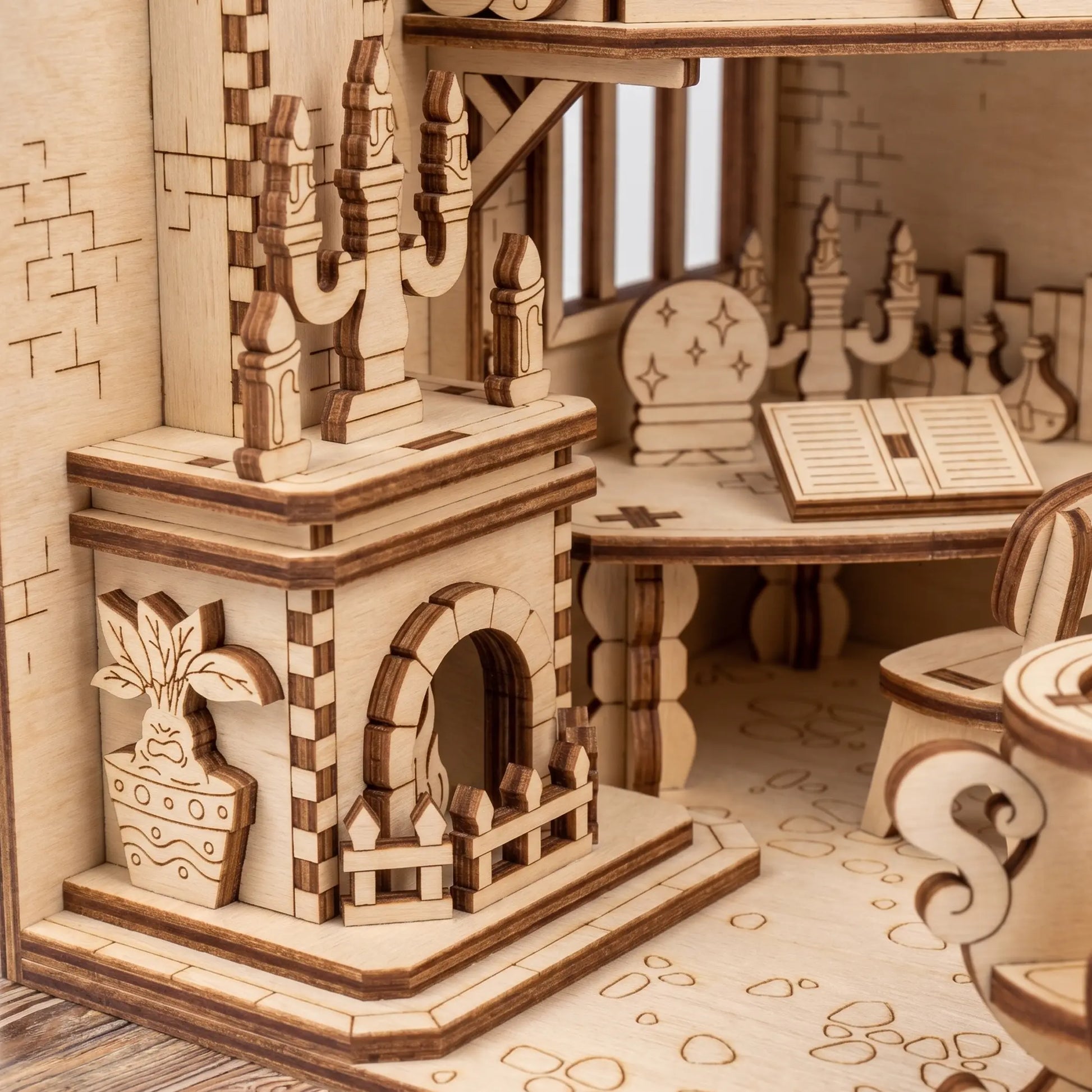 Wooden laser cut model of a room with a fireplace with detailed architecture and furniture.
