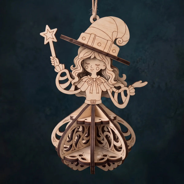A laser-cut wooden hanging ornament shaped like a whimsical wizard or fairy, with a tall hat, star wand, and layered decorative body, shown against a dark textured background.