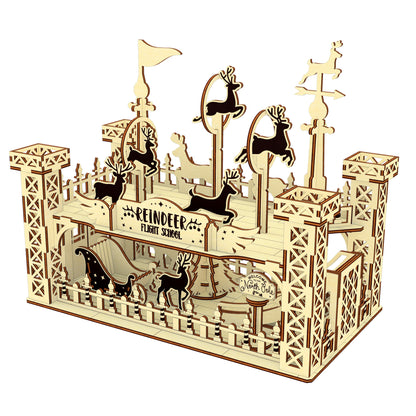 Side view of the wooden “Reindeer Flight School” scene made from a laser cut digital file, showing reindeer training hoops, towers, and barn-style gates, styled with holiday decor.